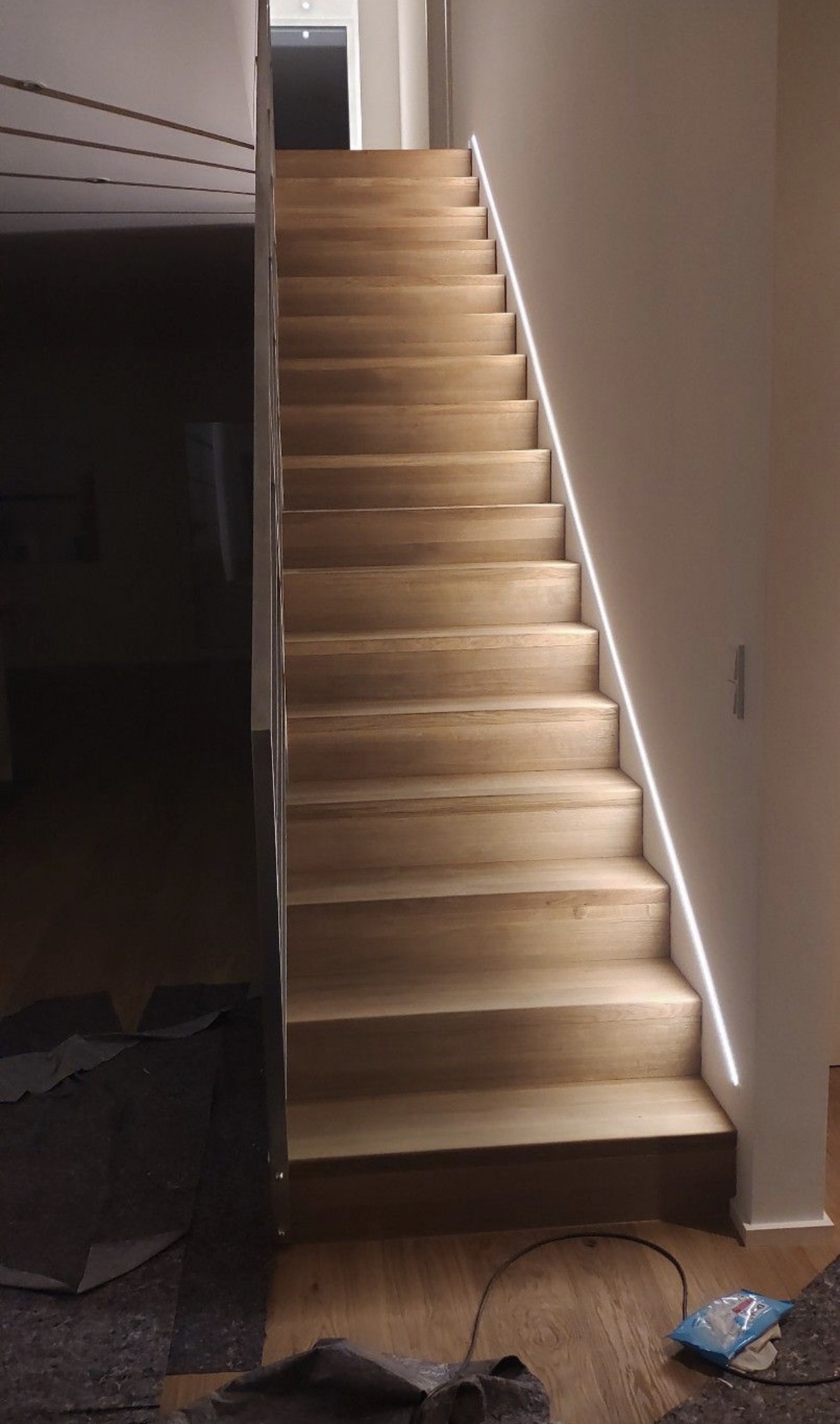 Wood staircase with a clean LED light line along the wall